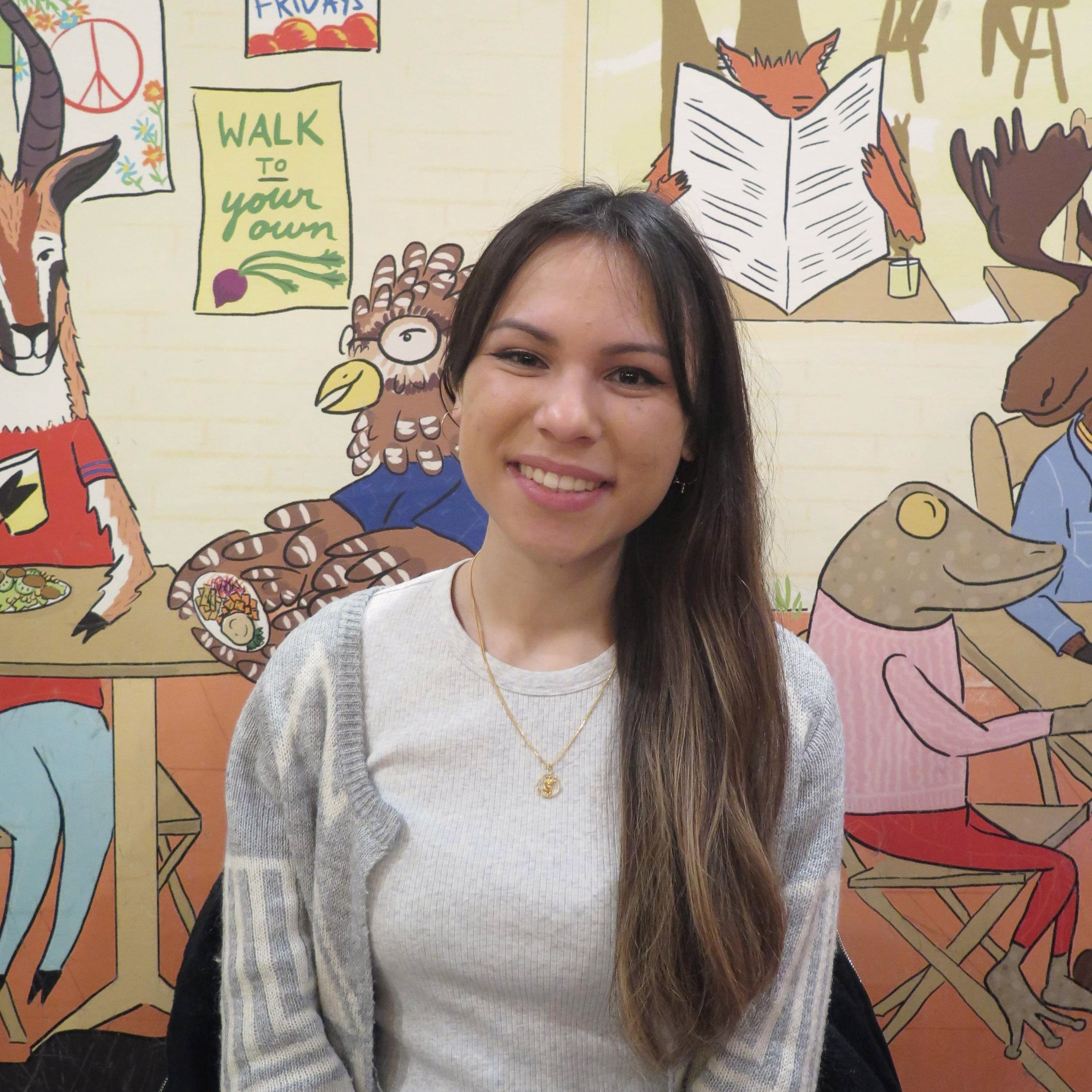 Photo of the author in front of a cartoon mural